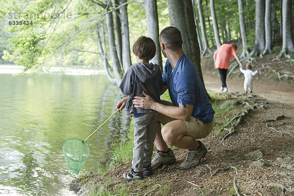 Vater und Sohn fischen im Wald  beide schauen weg