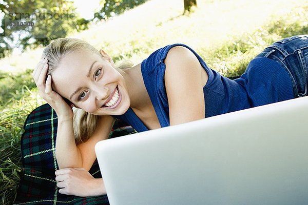 Lächelnde Frau mit Laptop im Freien