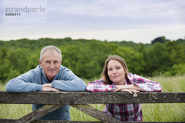 Vater und Tochter auf Holzzaun