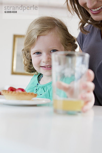 Mädchen mit einem Glas Saft auf dem Tisch