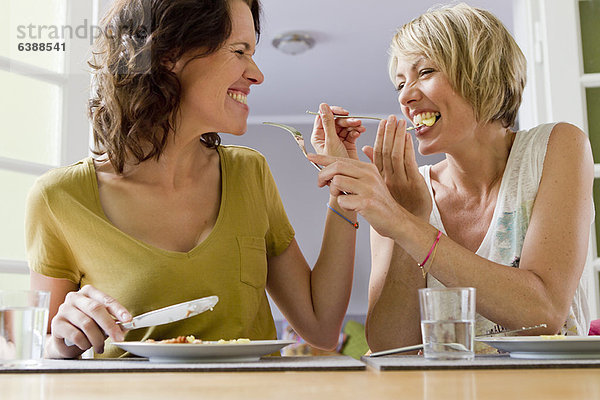 Lächelnde Frauen beim gemeinsamen Mittagessen