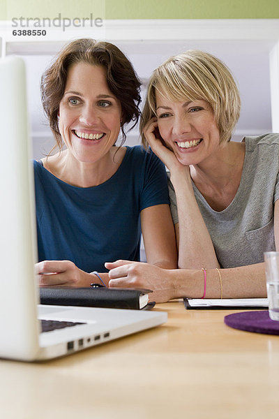Frauen  die ihren Laptop zusammen benutzen