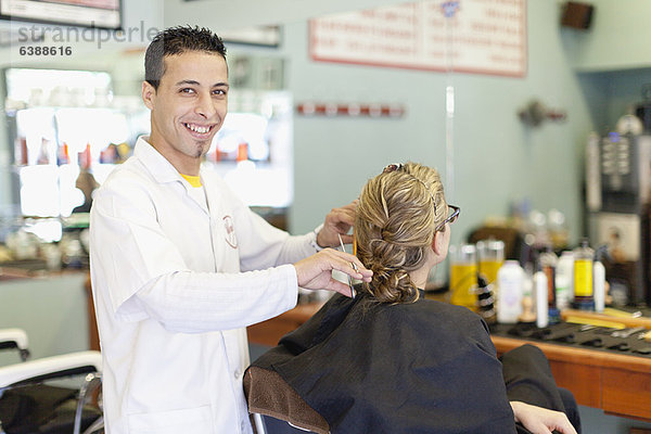 Friseur bei der Arbeit am Kunden im Geschäft