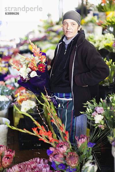 Florist mit Blumenstrauß am Stand