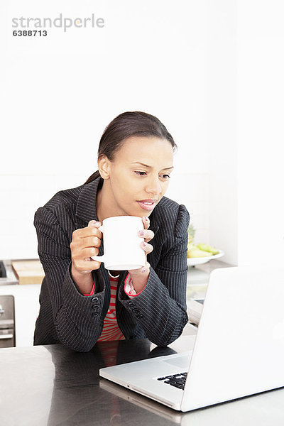 Geschäftsfrau bei der Arbeit mit einer Tasse Kaffee