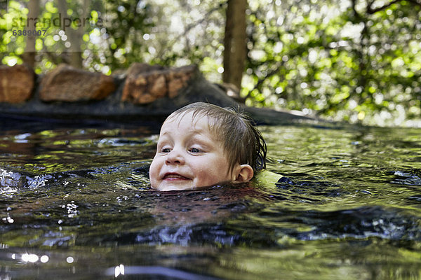 Junge schwimmt im Fluss im Wald