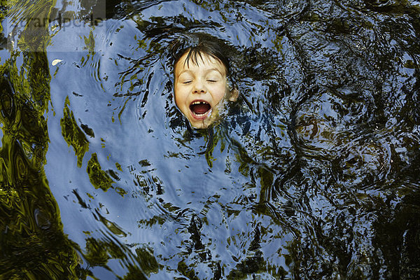 Lachender Junge schwimmt im Fluss