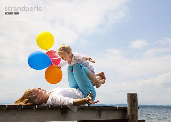 Mutter und Tochter spielen am Pier