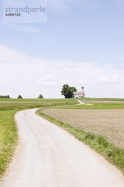 Schotterstraße in ländlicher Landschaft