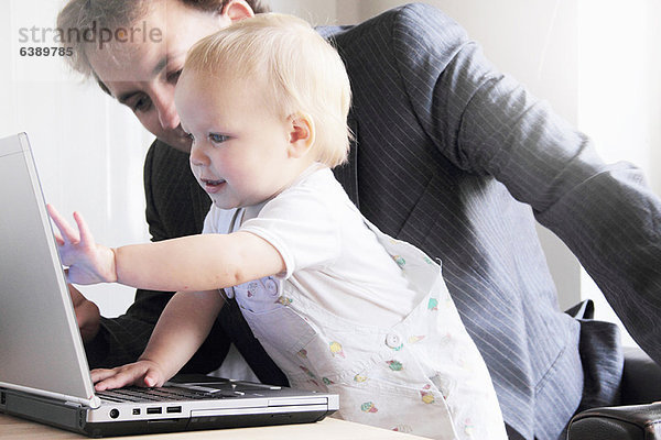 Vater und Kleinkind beim Spielen mit dem Laptop