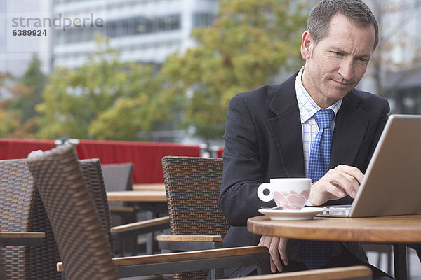 Geschäftsmann bei der Arbeit am Laptop im Café