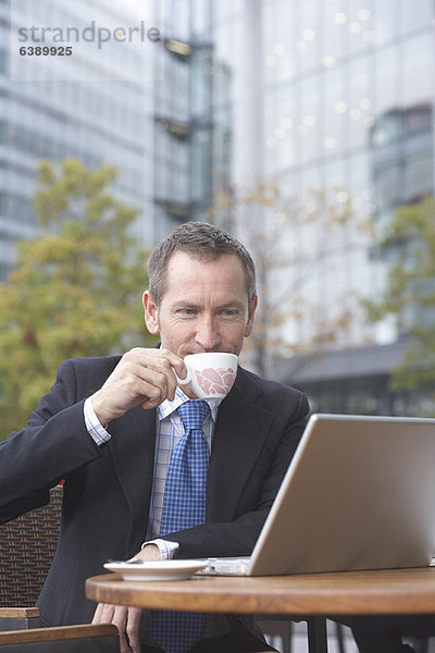 Geschäftsmann bei der Arbeit am Laptop im Café