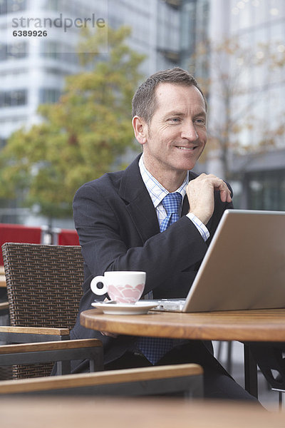 Geschäftsmann bei der Arbeit am Laptop im Café