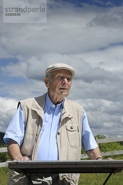 Ein alter Mann studiert eine Orientierungstafel im Gelände  Deutschland  Europa  ÖffentlicherGrund