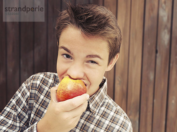 Portrait  Junge  Teenager  beisst in Apfel