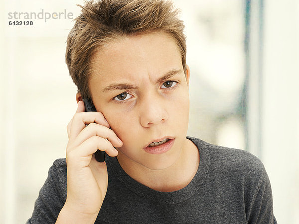Portrait  Junge  Teenager  telefonierend mit Handy  wütend