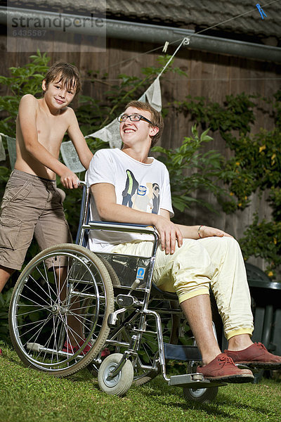 Jugendlicher im Rollstuhl mit Begleiter