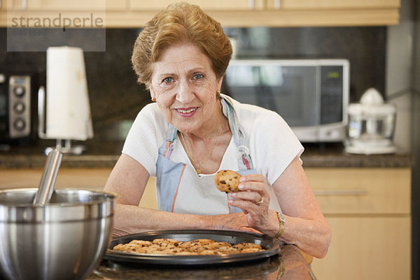 Eine ältere Frau mit frisch gebackenen Keksen
