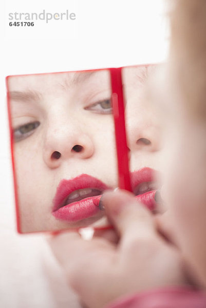 Mädchen mit Handspiegel und Lippenstift