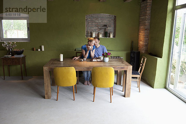 Ein liebevolles Pärchen am Tisch mit einem persönlichen Organizer und Kaffee