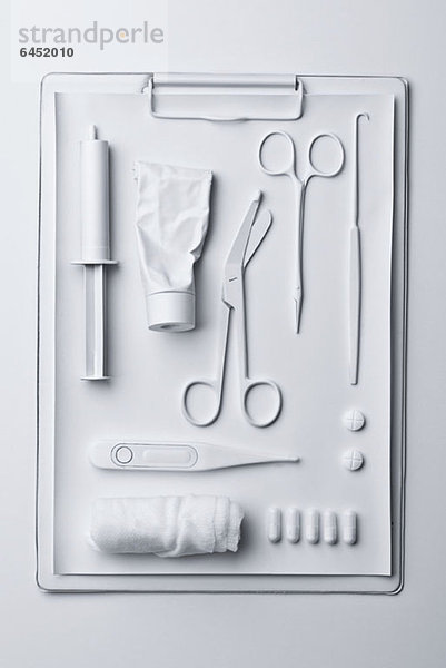 Medizin und medizinische Geräte weiß gestrichen und auf einem Klemmbrett ausgelegt