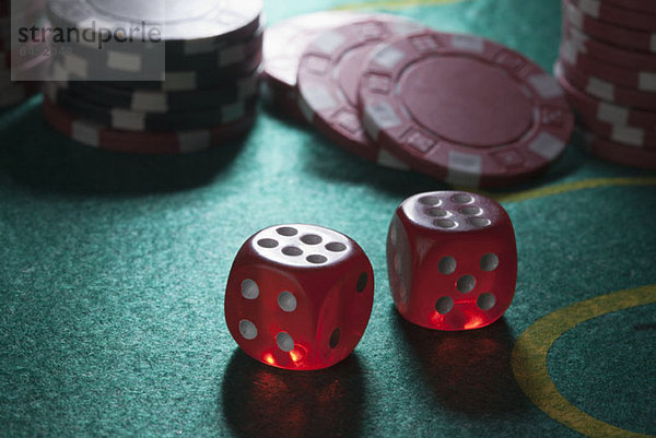 Zwei gewürfelte Sechsen auf einem Craps-Tisch  Spielchips im Hintergrund