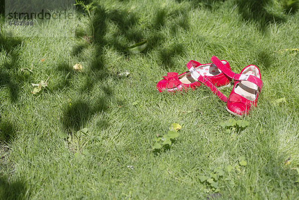 Rosa Schuhe eines Kindes auf Gras