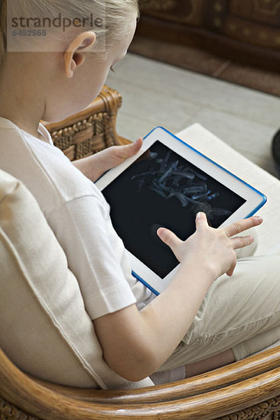 Ein Mädchen sitzend mit einem digitalen Tablett