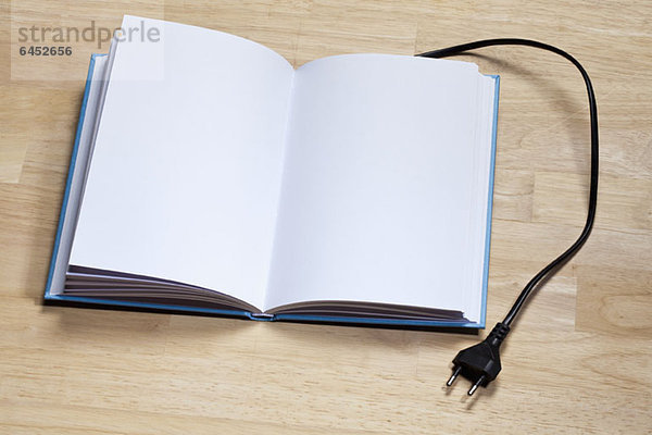 Ein Hardcover-Buch mit einem elektrischen Stecker.