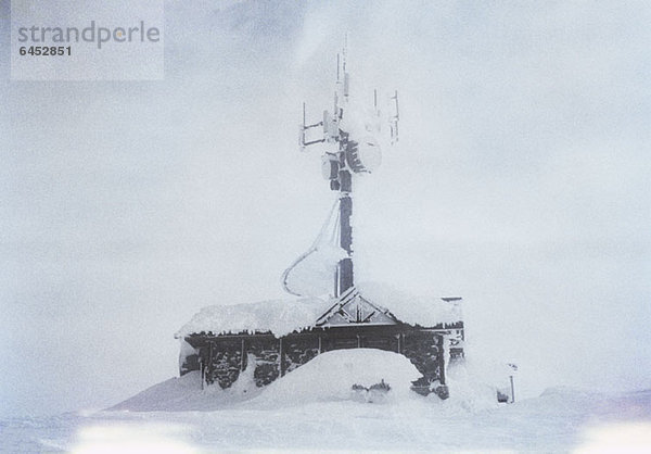 Ein Gebäude mit einer großen  schneebedeckten Antenne