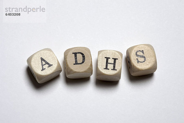 Buchstabenwürfel mit der Schreibweise ADHS (Attention Deficit Hyperactivity Disorder)