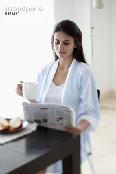 Frau beim Lesen der Morgenzeitung