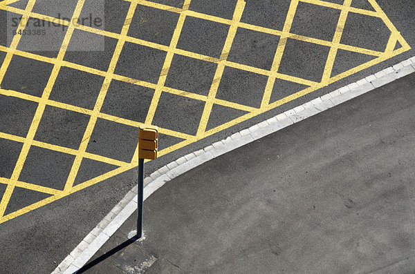 Gelbe Linien auf der Straße zur Markierung des Halteverbots in der Nähe einer roten Ampel/Kreuzung