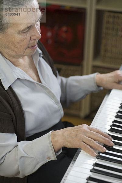 Eine ältere Frau beim Klavierspielen