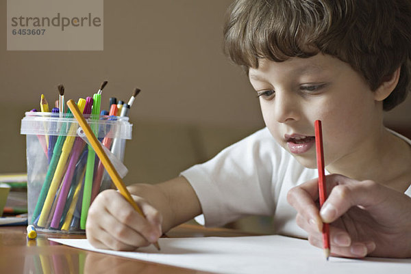 Ein Junge und ein Freund zeichnen mit Buntstiften  Blickwinkel des Jungen