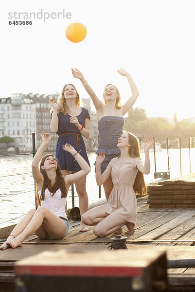 Vier Freundinnen  die einen Ball auf einem Steg an der Spree herumwerfen  Berlin  Deutschland