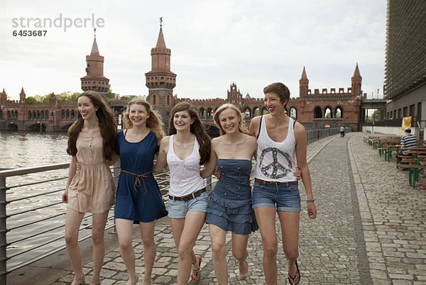 Fünf Freundinnen gehen Seite an Seite an der Oberbaumbrücke  Berlin  Deutschland