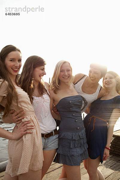 Fünf junge Freundinnen zusammen auf einem Steg
