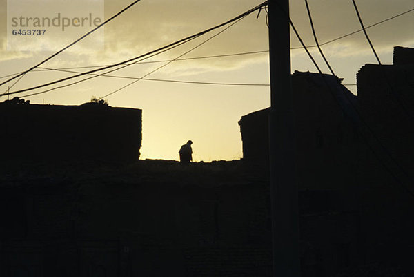 Silhouettierter Mann auf dem Dach