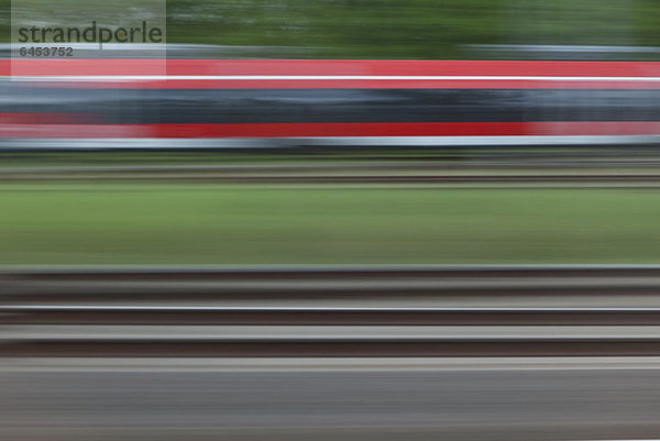 Eisenbahnschienen und ein Zug  verschwommene Bewegung  von einem fahrenden Zug aus gesehen