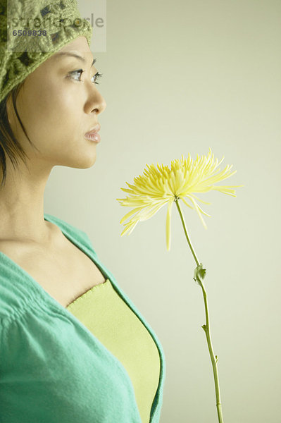 Portrait of a junge Frau hält eine Blume
