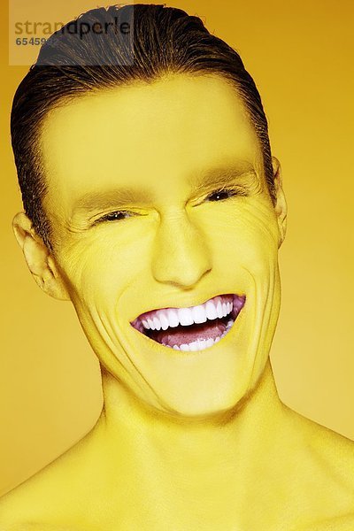 Studioaufnahme  Portrait  Mann  lachen  gelb  streichen  streicht  streichend  anstreichen  anstreichend  jung