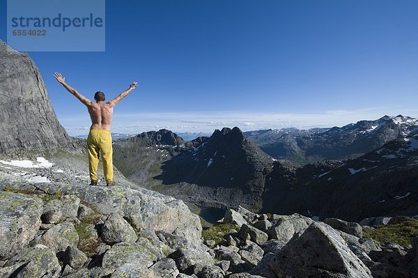 stehend  Berg  Mann  heben  Berggipfel  Gipfel  Spitze  Spitzen  Freier Oberkörper