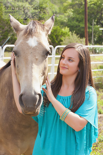 USA  Texas  Teenage girl streichelndes Pferd  lächelnd  Portrait