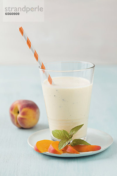 Vanilla and peach smoothie on table