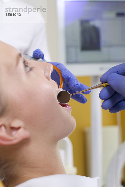 Deutschland  Brandenburg  Strausberg  Zahnarzt bei der Untersuchung von Patientenzähnen