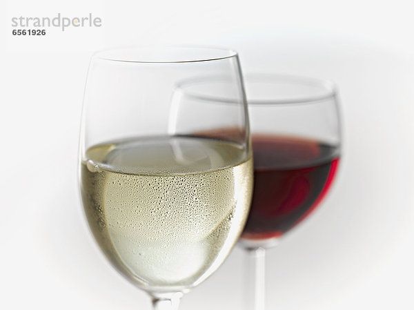 Glasses of white and red wine on white background