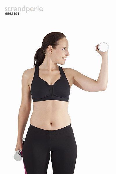 Young woman exercising with dumbbell  smiling