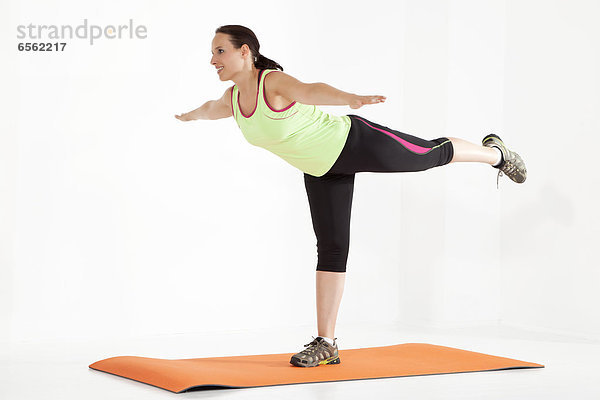 Young woman stretching on exercise mat