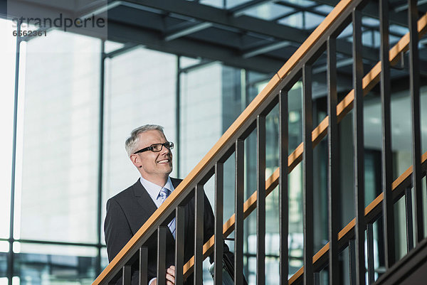 Deutschland  Stuttgart  Geschäftsmann beim Aufstieg auf die Bürotreppe